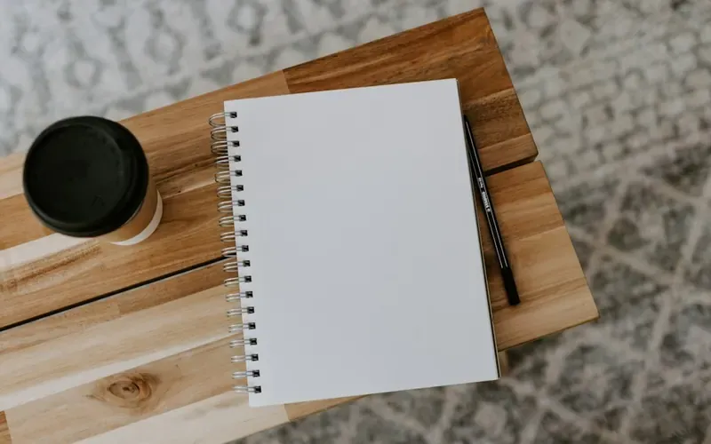 Carnet ouvert et café sur un bureau, pour préparer un divorce amiable