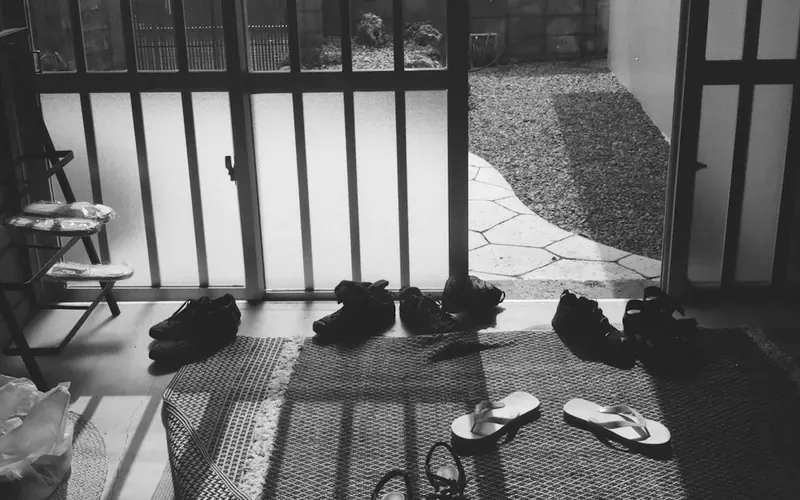 Chaussures rangées sur le tapis d’une entrée ensoleillée